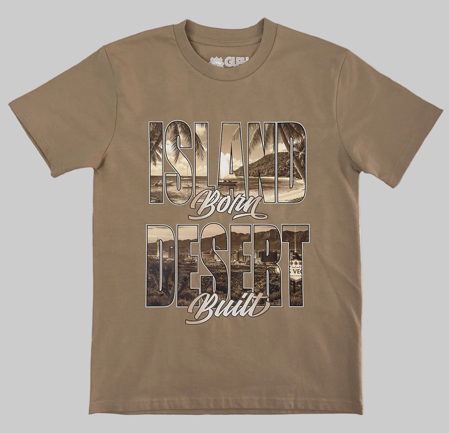 The front print of the Island Born Desert Built Classic Tee in Khaki. Features a beach scene within the word "Island" and the desert landscape and Las Vegas strip within the word "Desert"
